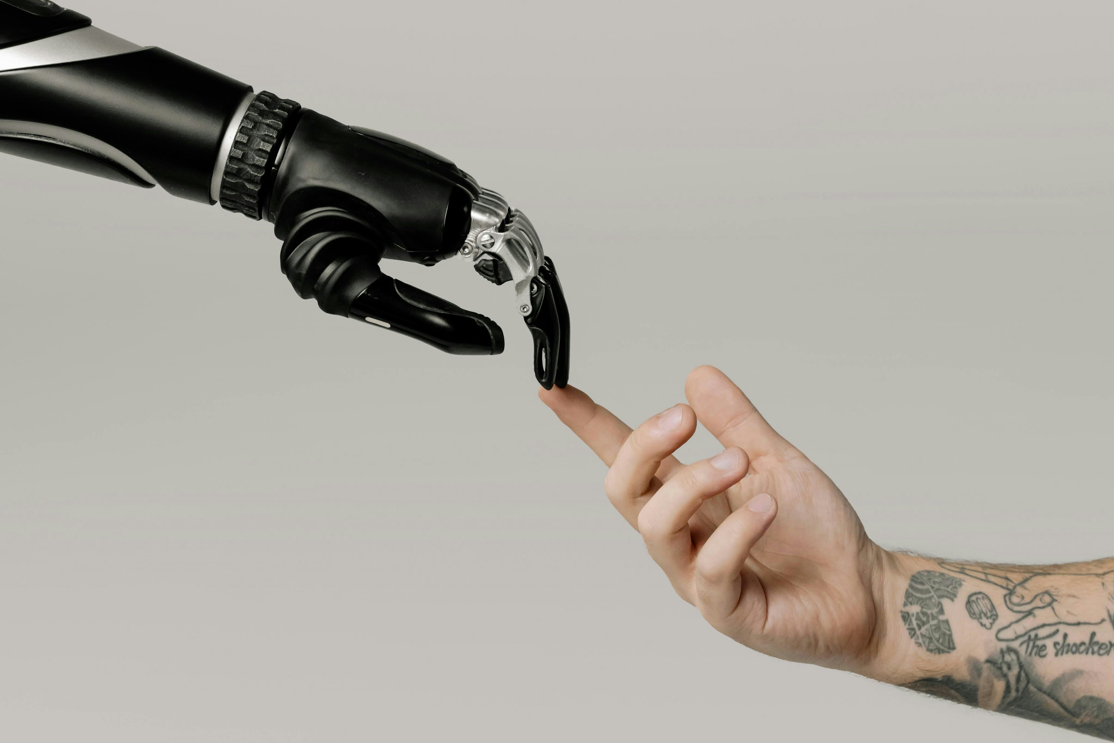 a human hand and a robot hand touching fingers