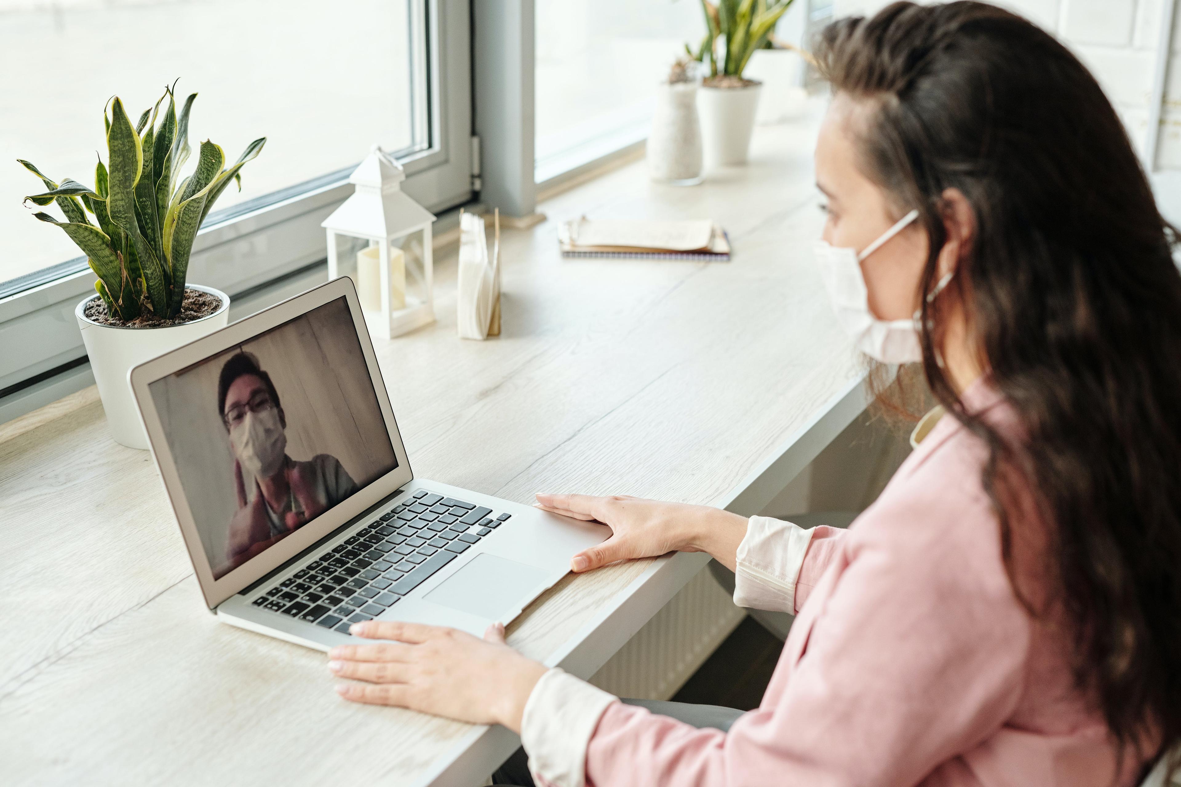 person sitting at a computer on a telehealth doctor appointment