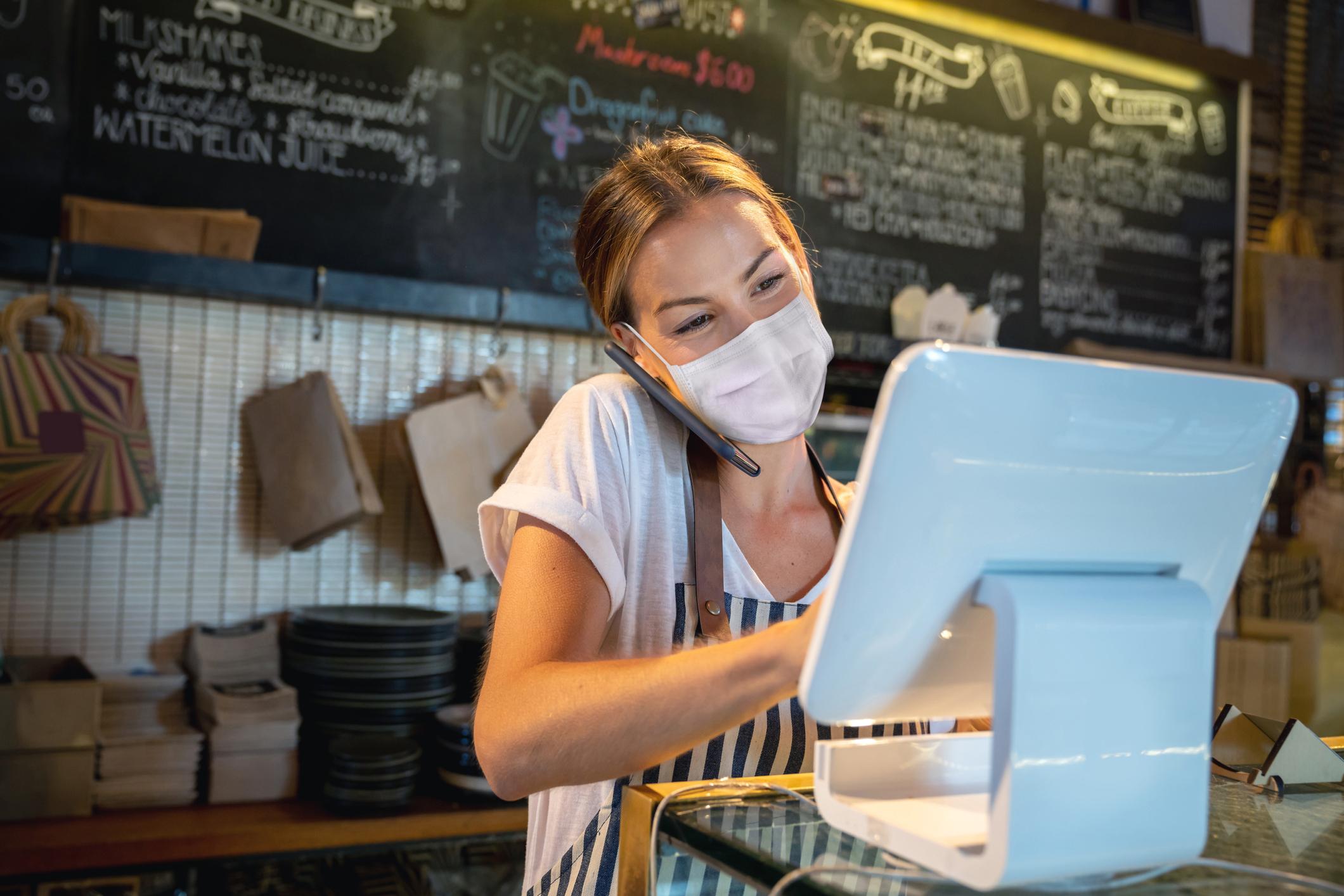 person working at check out station at retail store.