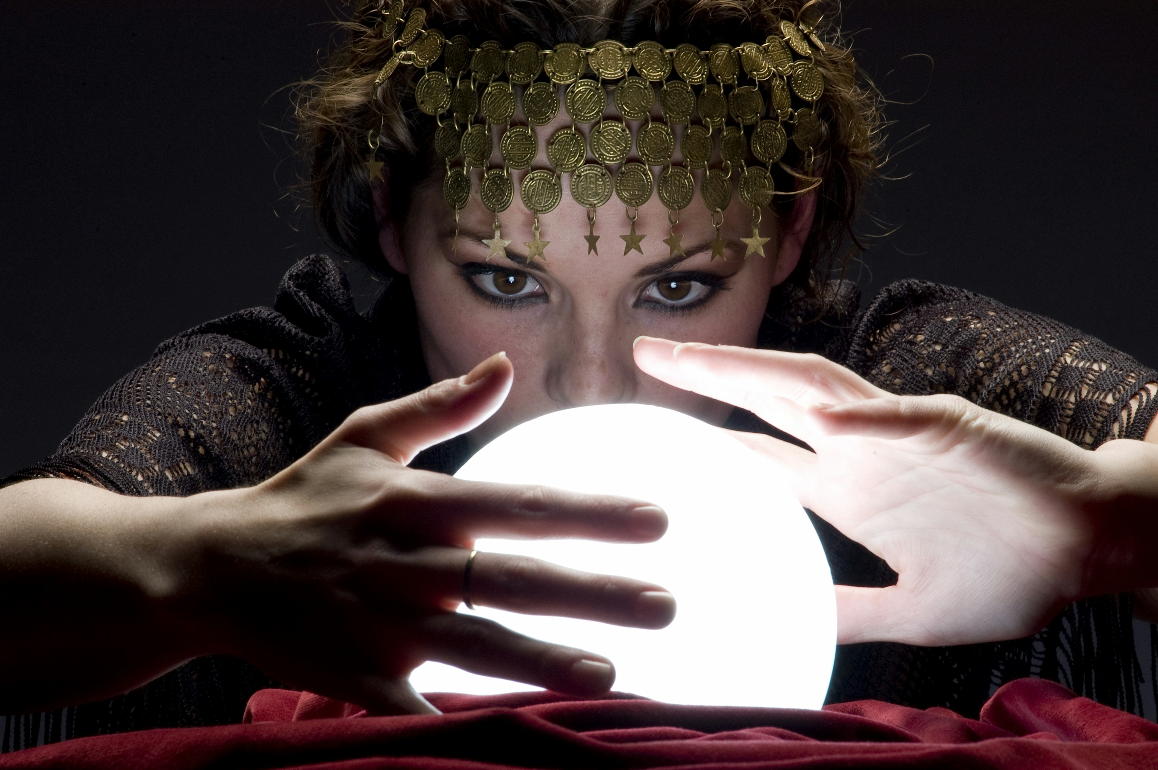 fortune teller hovering over glowing ball.