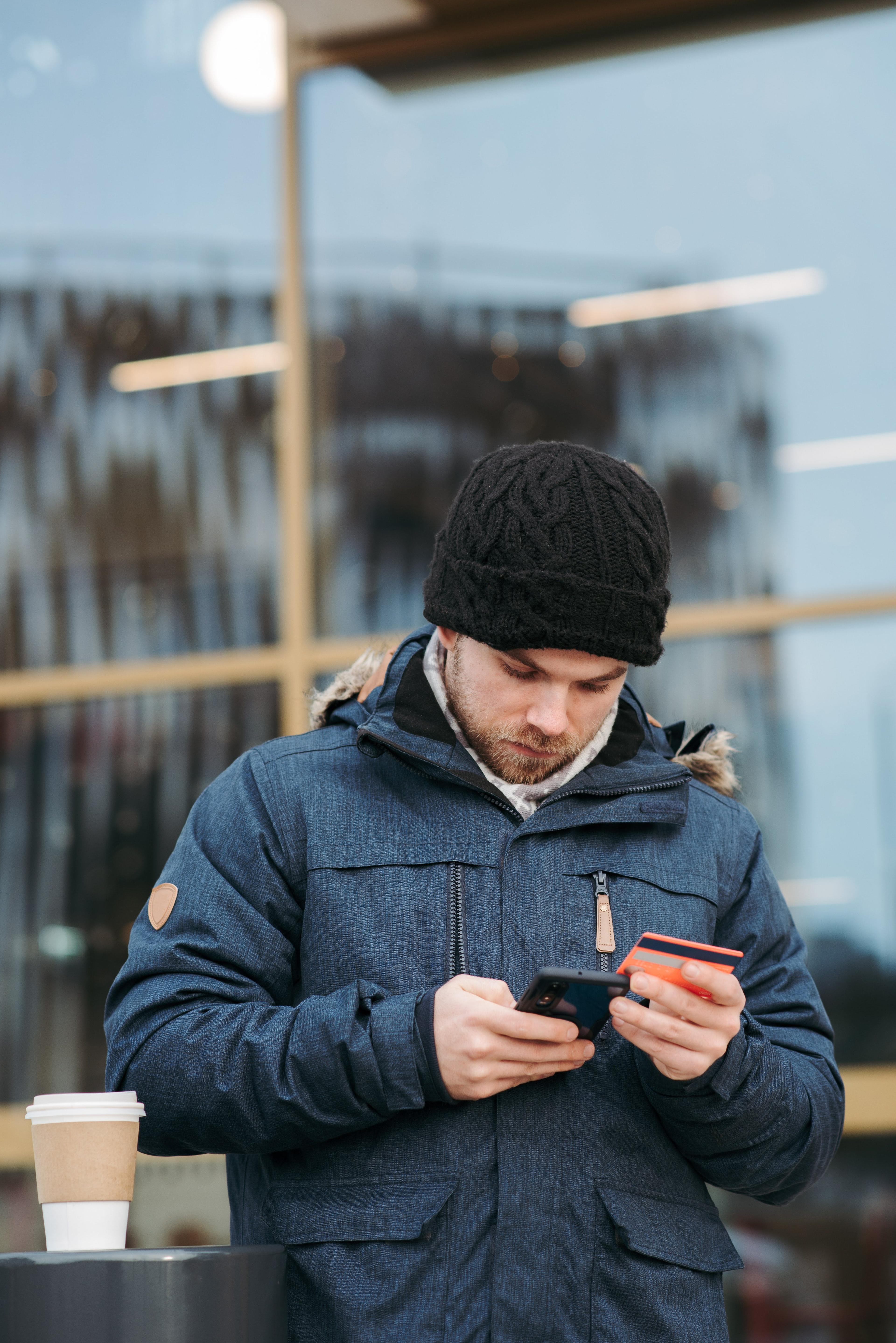 person using a digital banking app on their phone while looking at credit card.