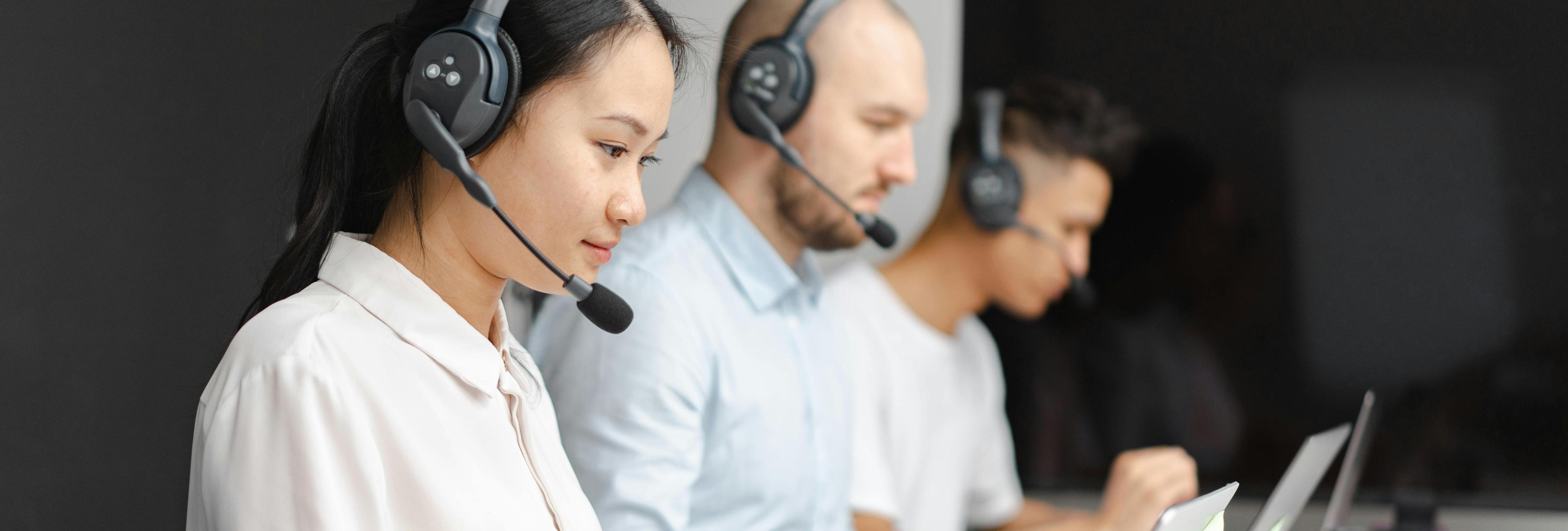 Three customer service representatives collecting feedback from users over the phone.