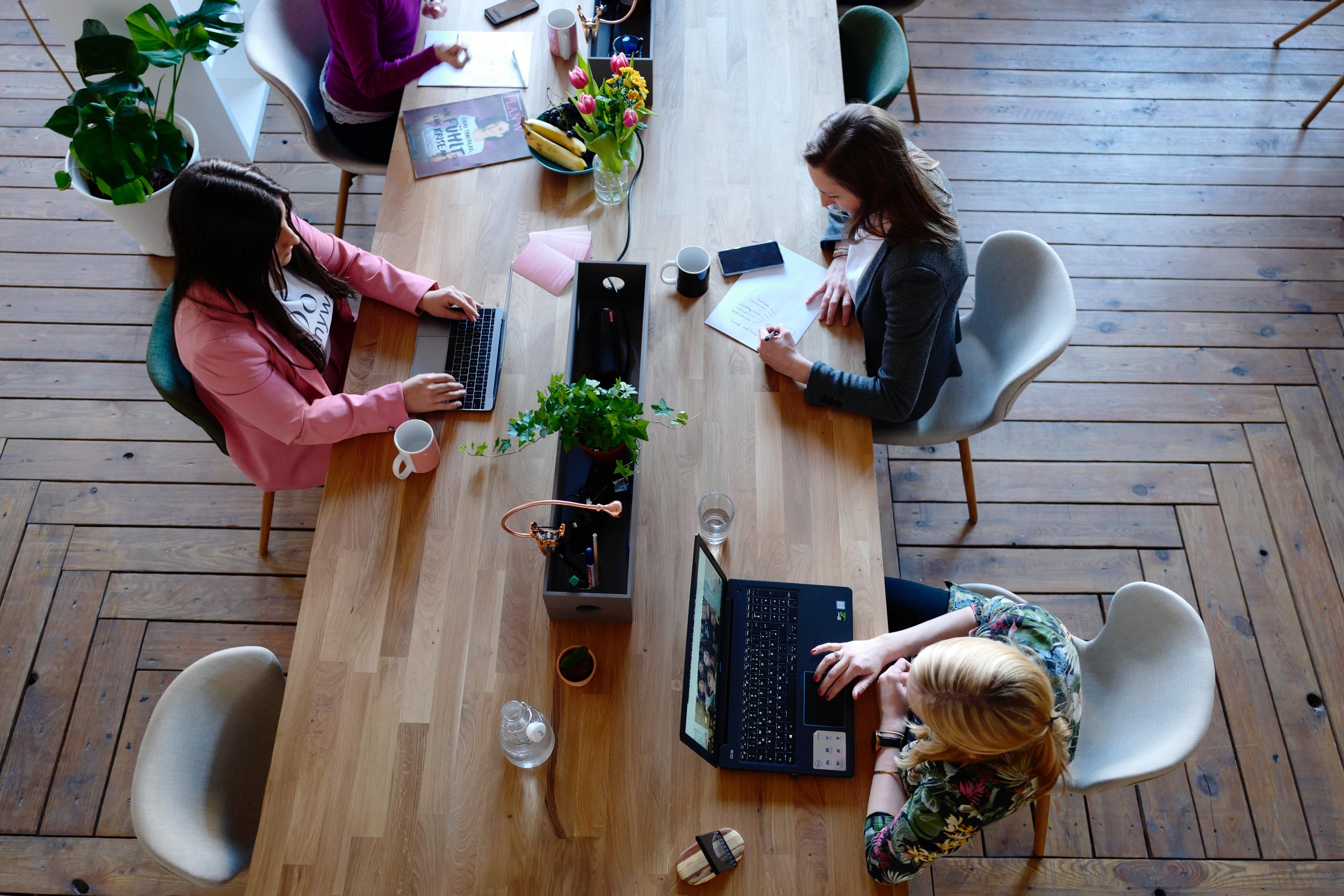 3 people working on laptops at a table together