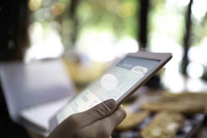 person holding a phone with a fintech app on the screen