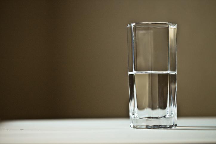 a half full glass of water on top of a table